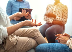 Drei Frauen und ein Mann diskutieren sitzend