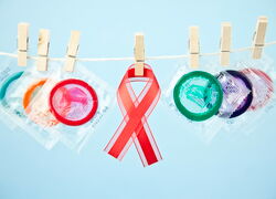bunte Kondome und AIDS-Schleife an Wäscheleine