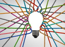 Bunte Fäden sind so gespannt, dass sie eine Glühbirne formen.