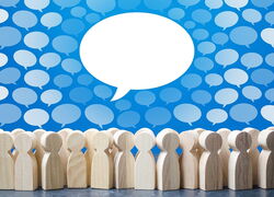 Holzfiguren, die Personen darstellen, mit Sprechblasen