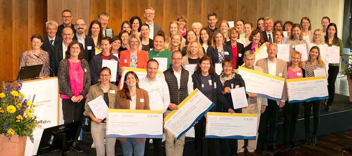 Gruppenfoto der Teilnehmerinnen und Teilnehmer auf Bühne